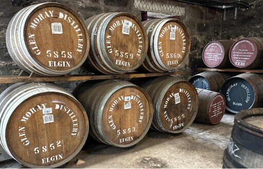 Glen Moray: de vaten liggen opgestapeld te rijpen. Er zijn vaten met bruine deksel en rode en groene. Op de vaten staat Glen Moray Distillery - Elgin